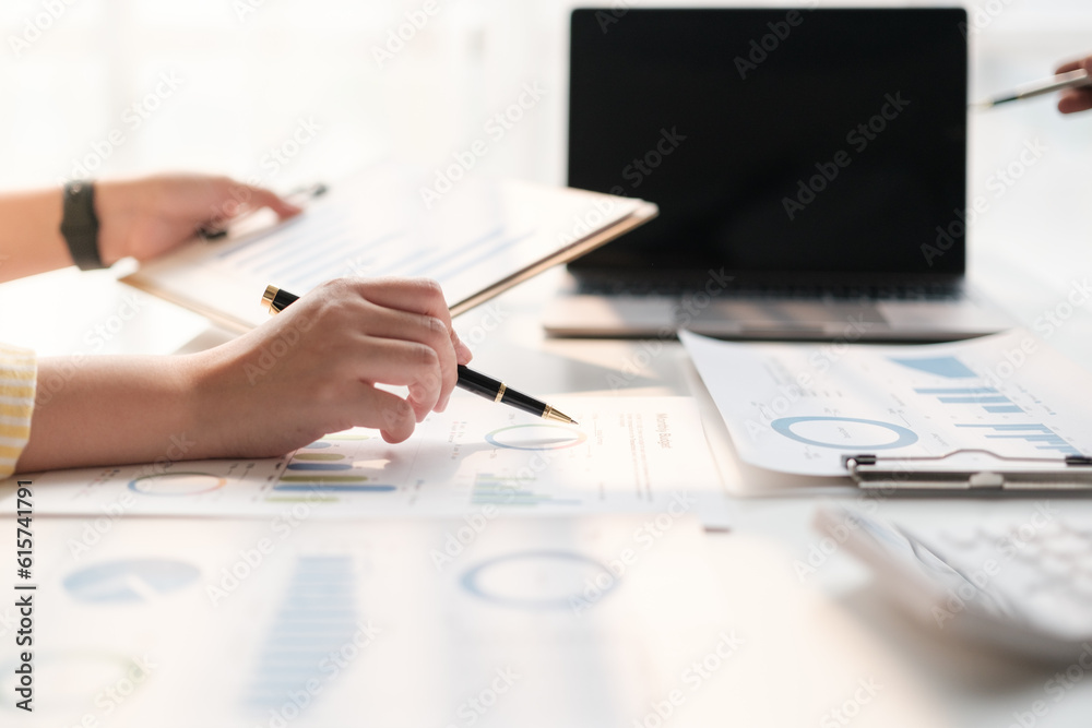 Team of two asian male and female business people working together discussing new financial graph data on office table with laptop and digital tablet. Team of two asian male and female business people working together discussing new financial graph data on office table with laptop and digital tablet.
