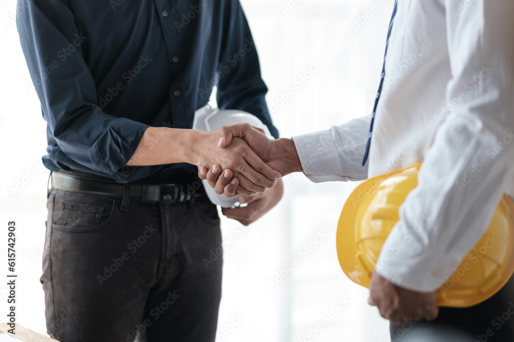 Close-up image of an engineer shaking hands with his coworker during the meeting. teamwork, building trust, unity