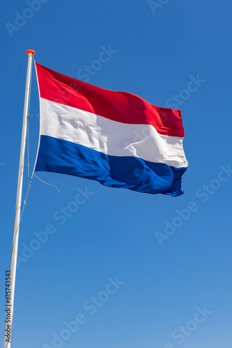 Waving Dutch flag in front of a blue sky in The Netherlands