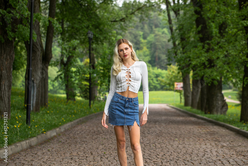 Young sexy blonde model in a short denim skirt