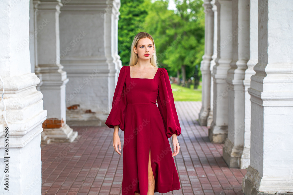Portrait of a young beautiful blonde girl in an evening burgundy dress Portrait of a young beautiful blonde girl in an evening burgundy dress