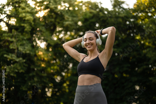 Sport girl with headphones listening to music while prepairing for outdoors workout