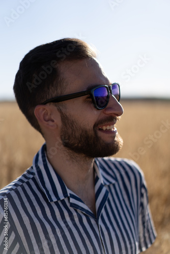 Portrait of a young man with glasses: A sunlit day frames the confident gaze of a stylish young man, capturing his youthful charm.