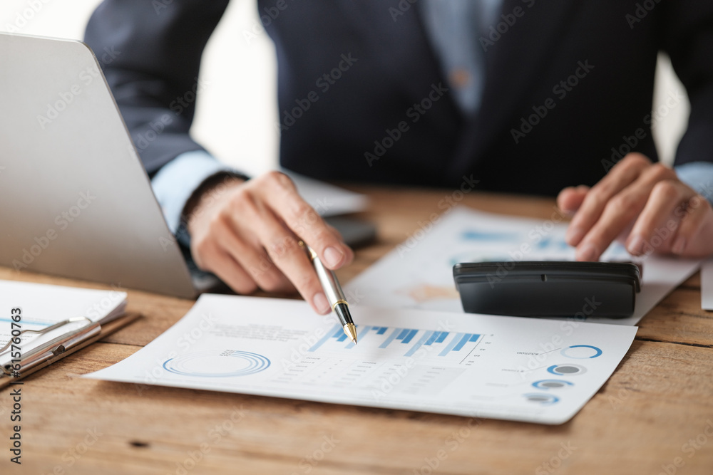 Close up young man with calculator counting making notes at home, hand is writing in a notebook. Savings finances concept