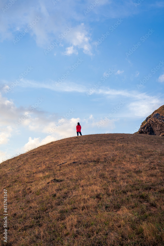 A tiny woman standing in the top of mountain with dramatic cloud in the sky (Chiang mai province, Thailand). amazing natural landscape. popular attractions best famous tourist attractions