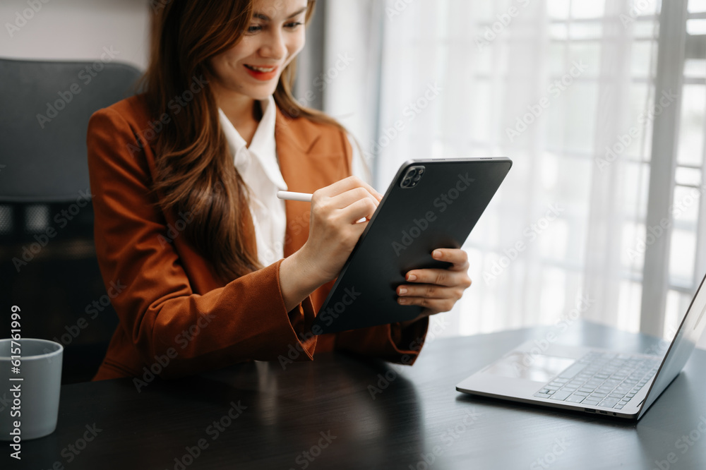 Business woman sitting front tablet ,laptop computer with financial graphs and statistics on monitor.at office. Business woman sitting front tablet ,laptop computer with financial graphs and statistics on monitor.at office.