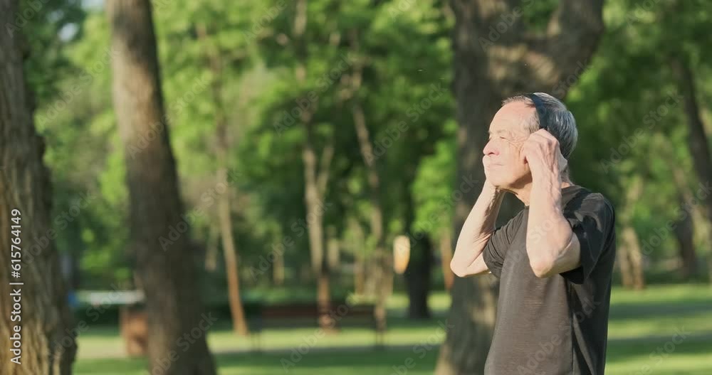 Senior old man puts on wireless headphones, start jogging in city park. Listen music while running, technology. Senior old man puts on wireless headphones, start jogging in city park. Listen music while running, technology.