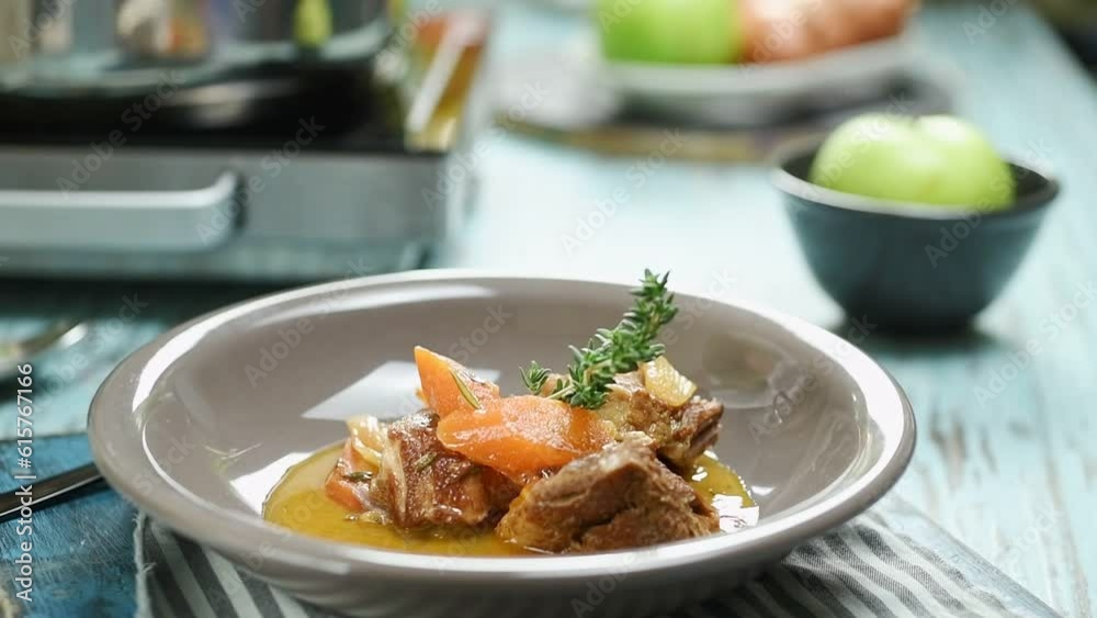 The chef adds thyme to the braised pork shoulder, served on the plate.
The chef adds thyme to the braised pork shoulder, served on the plate.
