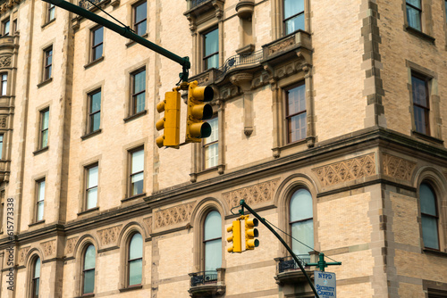 Traffic light signal in the city. American style yellow traffic light in New York City. Traffic in the city. Background with classical buildings.