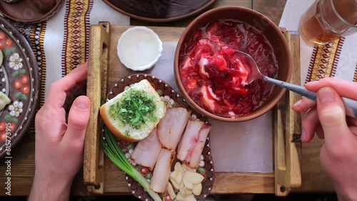 Traditional Ukrainian dish Borscht. Eating red Ukrainian borscht from first person POV. A hand stirs the first course of beetroot with a spoon. photo