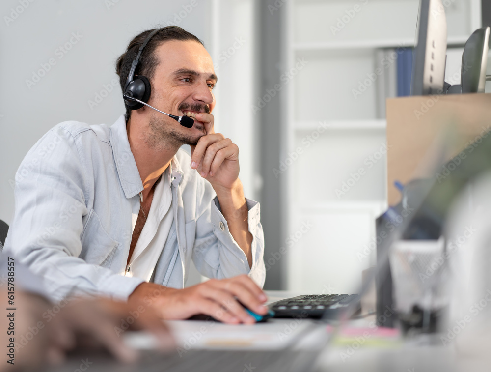 Male customer service operator wear headset working in call center office to support people with telemarketing technology. Young man using headphone and microphone talking to client at helpdesk center Male customer service operator wear headset working in call center office to support people with telemarketing technology. Young man using headphone and microphone talking to client at helpdesk center