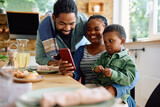 Happy black family making video call over smart phone at home.
