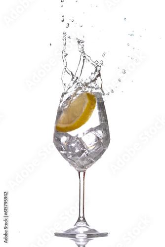 Slice of lemon inside water creating a splash against white background. 