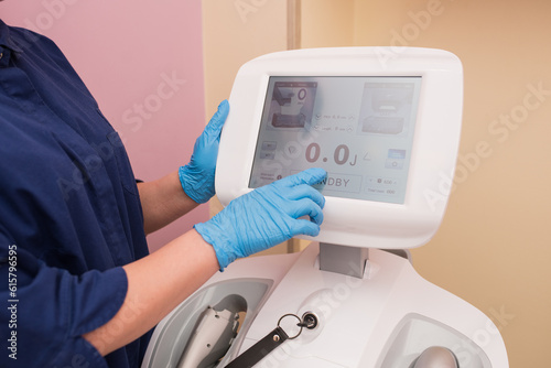 the cosmetologist includes a cosmetology device for the prevention of aging, an ultraforming device, a cosmetologist's hand in a blue glove, hardware cosmetology
