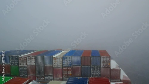 Pacific ocean - 02.06.2023 Ultra large container ship full of cargo containers passing through the snow storm in Pacific ocean during winter time. 