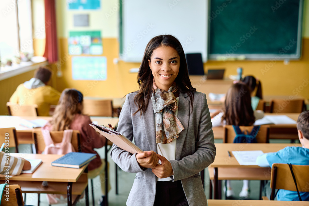 Portrait of happy Hispanic teacher during class at elementary school looking at camera.