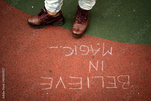 Positive message writen on the ground. Believe in magic message. photo