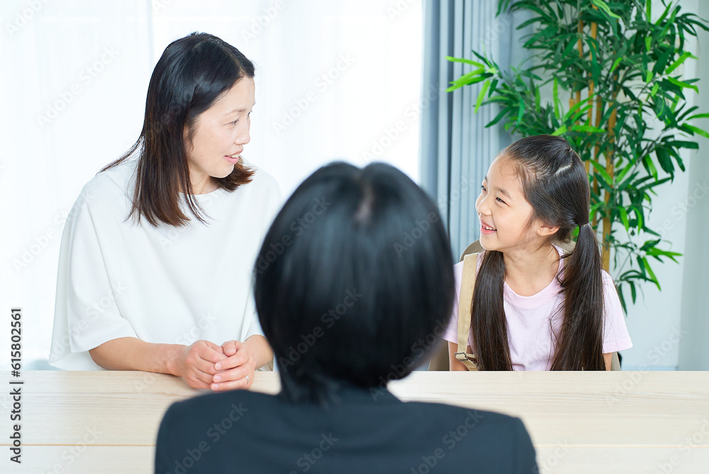 親子とスーツ姿の女性の会話シーン