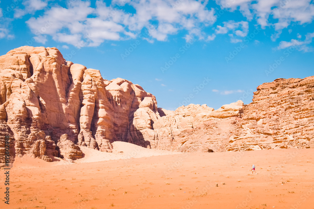 Female tourist solo hike explore travel trekking in Wadi Rum Desert, Jordan. Beautiful rock formations in Wadi-Rum desert, Jordan, Middle East Female tourist solo hike explore travel trekking in Wadi Rum Desert, Jordan. Beautiful rock formations in Wadi-Rum desert, Jordan, Middle East