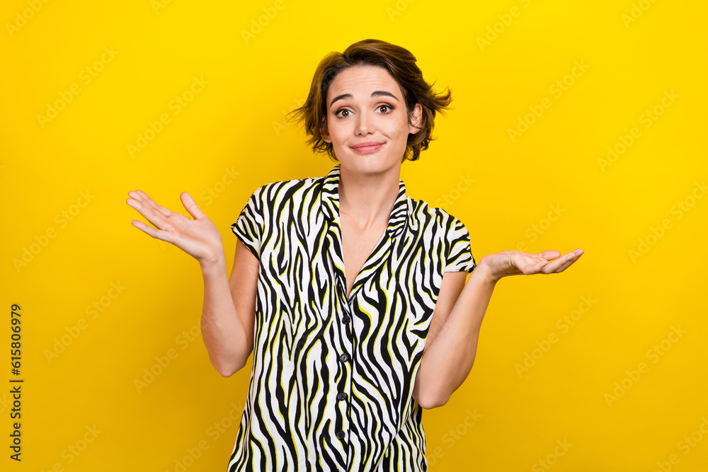 Portrait of pretty funny guilty woman with short hairstyle wear striped blouse shrugging shoulders isolated on yellow color background
