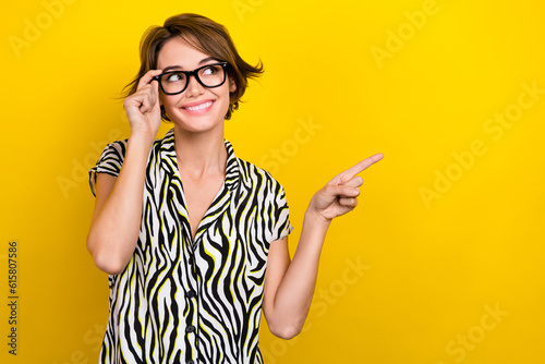 Photo portrait of cute lady worker direct finger empty space optics specs wear print blouse isolated yellow color background