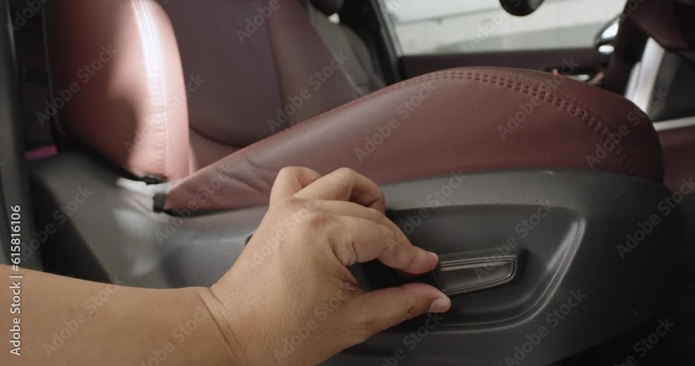 Men test buttons for electric adjustment of seats in the car to sit comfortably. Men test buttons for electric adjustment of seats in the car to sit comfortably.