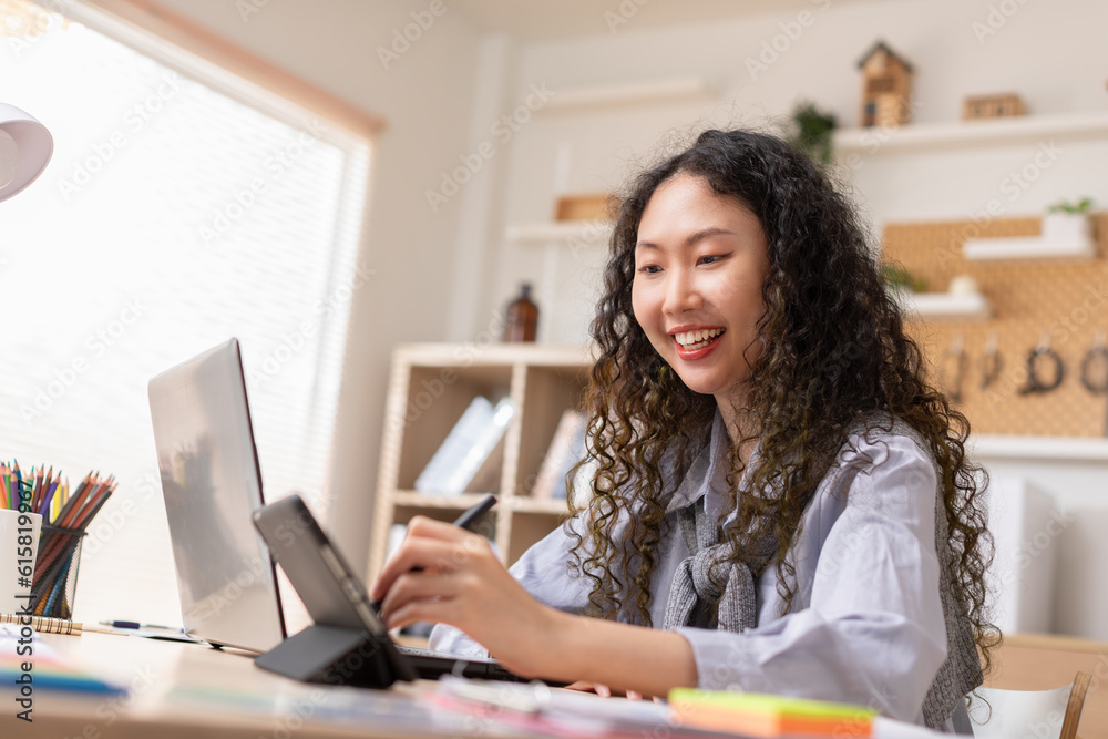 Asian business owner woman smile using stylus pen drawing design her work in home office. Confident designer or creative woman work on laptop. Successful millennial female small business owner concept Asian business owner woman smile using stylus pen drawing design her work in home office. Confident designer or creative woman work on laptop. Successful millennial female small business owner concept
