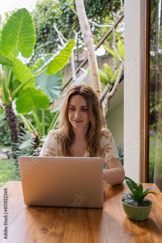 Freelancer woman work by laptop on vacation. Freelancing on the tropical paradise resort.
