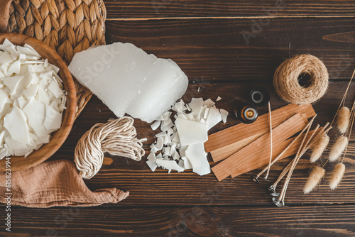 Set for crafting candle on wooden background. Eco soy wax and candle making tools top view, flat lay. DIY candles. Hobby concept photo