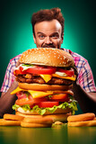 Large hamburger on the table with a very hungry man in a background. Ai generative image