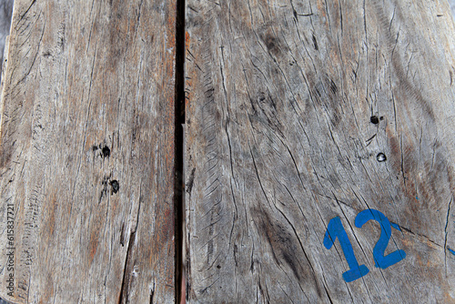 Number 12 painted in blue over a wooden table