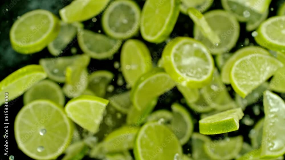 Super slow motion of flying lime slices on black background. Filmed on high speed cinema camera, 1000 fps. Camera placed on high speed cine bot, tracking the object. Speed ramp effect.