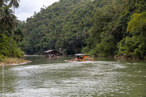 floating house sailing in a river in the jungle