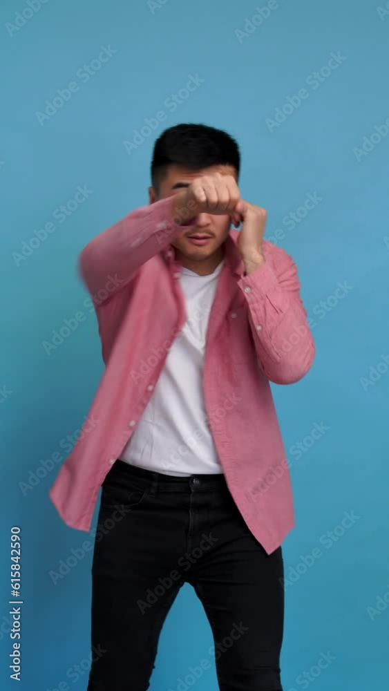 Strong man shows his fists in studio. Vertical video. Strong man shows his fists in studio. Vertical video.