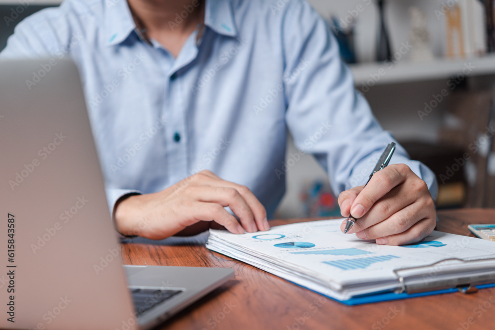 business documents data report chart and graph diagram on desk with laptop.Man working finance paperwork marketing business documents data report chart and graph diagram on desk with laptop.Man working finance paperwork marketing