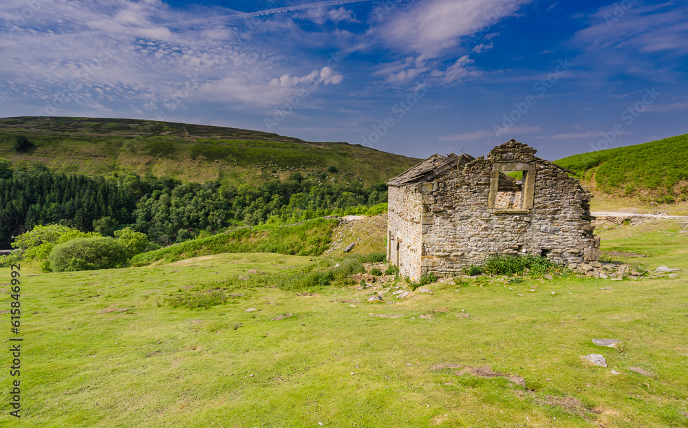 Abandoned stone barn and Dales Scenery in Swaledale, Yorkshire Dales National Park.