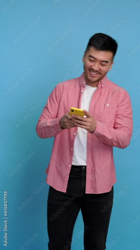 Asian man answering messages with mobile phone. Vertical video. Asian man answering messages with mobile phone. Vertical video.
