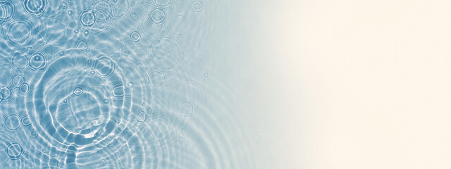 abstract rain drops with sun lights from above, beautiful water background with copy space for products or text, concept banner for beach vacation or beauty spa