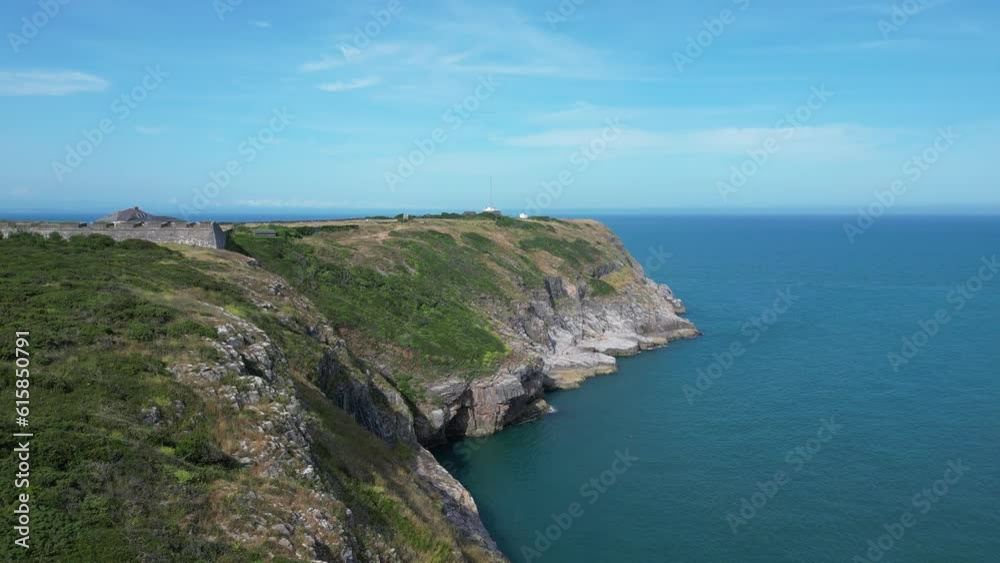 Berry Head, South Devon, England: DRONE AERIAL VIEWS: The drone flies North East over rugged limestone cliffs towards Berry Head with its lighthouse and eighteenth century fortifications. Berry Head, South Devon, England: DRONE AERIAL VIEWS: The drone flies North East over rugged limestone cliffs towards Berry Head with its lighthouse and eighteenth century fortifications.