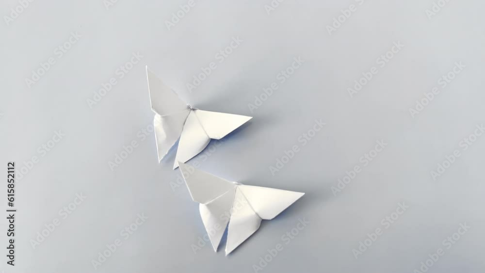 White paper origami butterfly on blue background. World Day of Peace. Day Against Humiliation. International Day Of Human Fraternity. International Day of Living Together in Peace