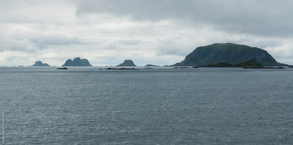 Summer view on Røstlandet island, Lofoten archipelago in the north of Norway. Cloudy, moody sky with ocean and hills, mountains. North Scandinavia.
