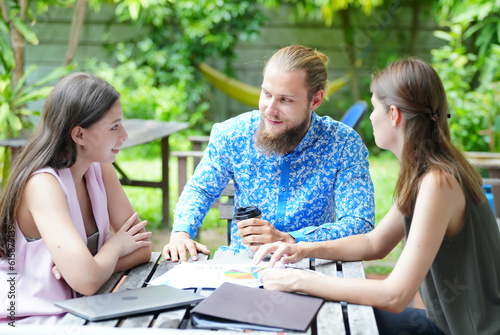 Young office worker presenting new financial plan to his partners during a meeting