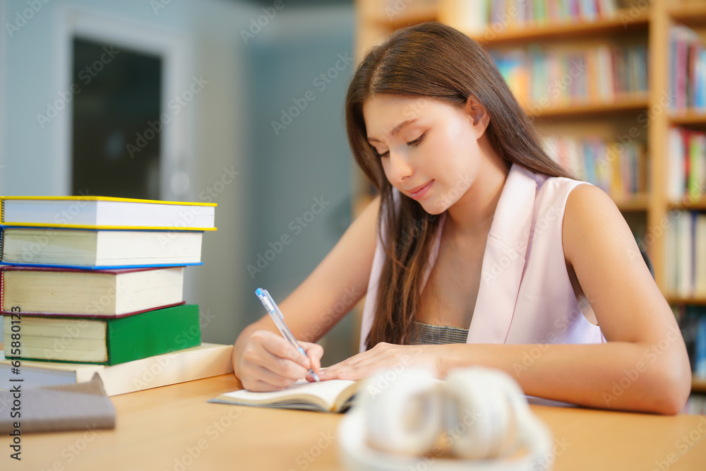 Smiling student girl in eyeglasses reading a red book in a library. School and education concept Smiling student girl in eyeglasses reading a red book in a library. School and education concept