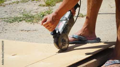 Carpentry works. A carpenter cuts an OSB board with an electric jigsaw. Wood sawing. Construction.