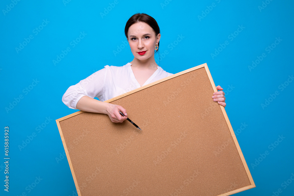 Young brunette woman with a blackboard on a blue background Young brunette woman with a blackboard on a blue background