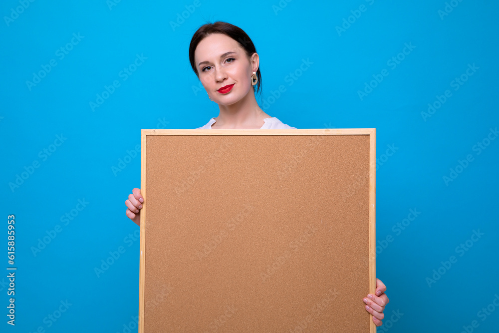 Portrait of a young woman with a blackboard on a blue background. Teacher, Students, buildings Portrait of a young woman with a blackboard on a blue background. Teacher, Students, buildings