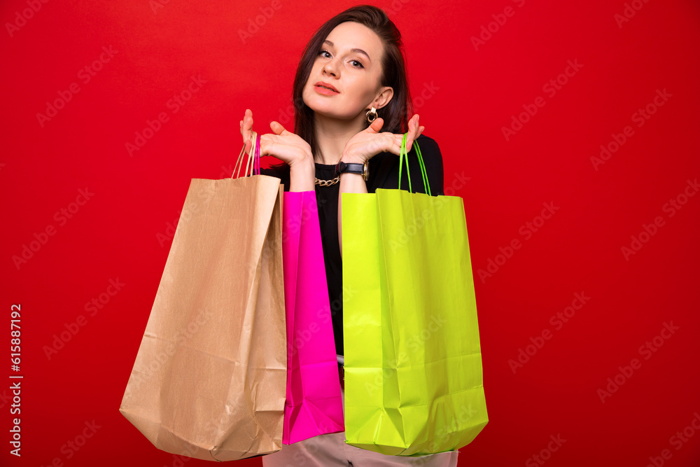 Attractive stylish woman holds bags in her hands after shopping at the mall Attractive stylish woman holds bags in her hands after shopping at the mall