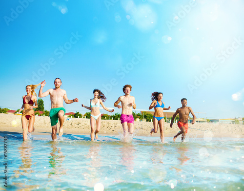Group of friends run in the blue sea. Concept of summertime © Designpics