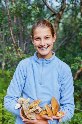 Portrait of cute girl with wild mushroom found in the forest