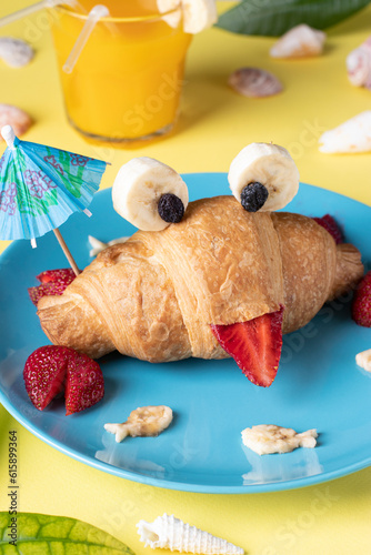 Fun food for kids - crab shaped croissant with strawberry and banana on blue plate